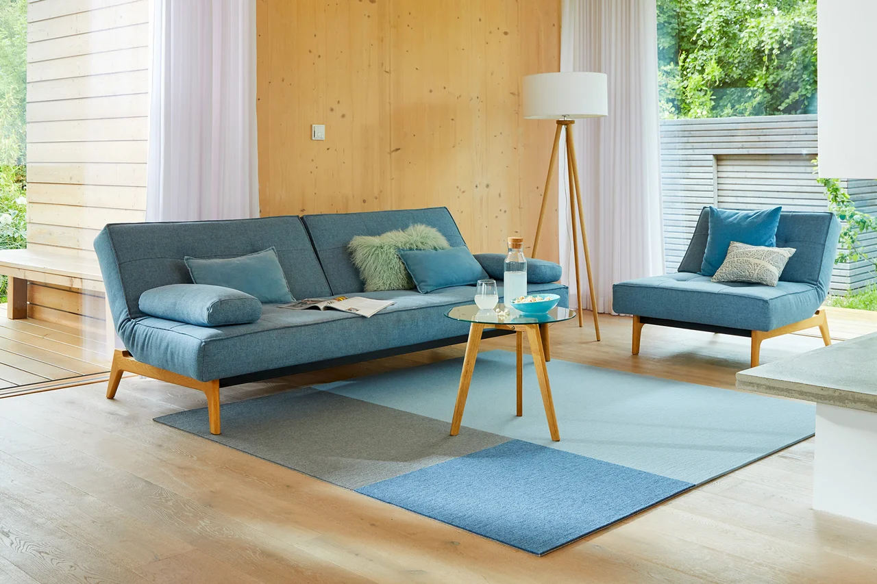 Ein Teppich liegt im Wohnzimmer. - Ein blau gemusterter Teppich liegt im Wohnzimmer.