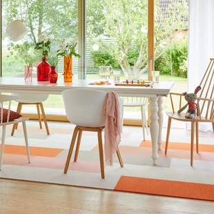 Teppich im Esszimmer - Ein orange beige gemusterter Teppich liegt unter dem Esszimmertisch.