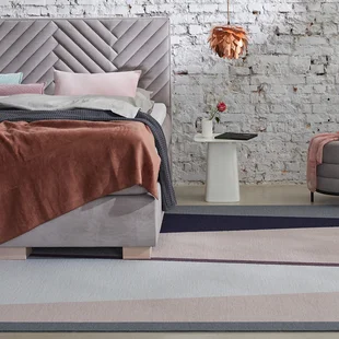 Teppich im Schlafzimmer - Ein Teppich liegt im Schlafzimmer halb unter dem Bett.